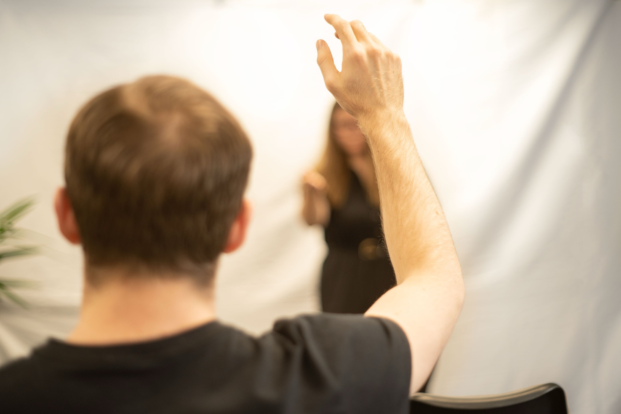 A member of an audience raising a hand
